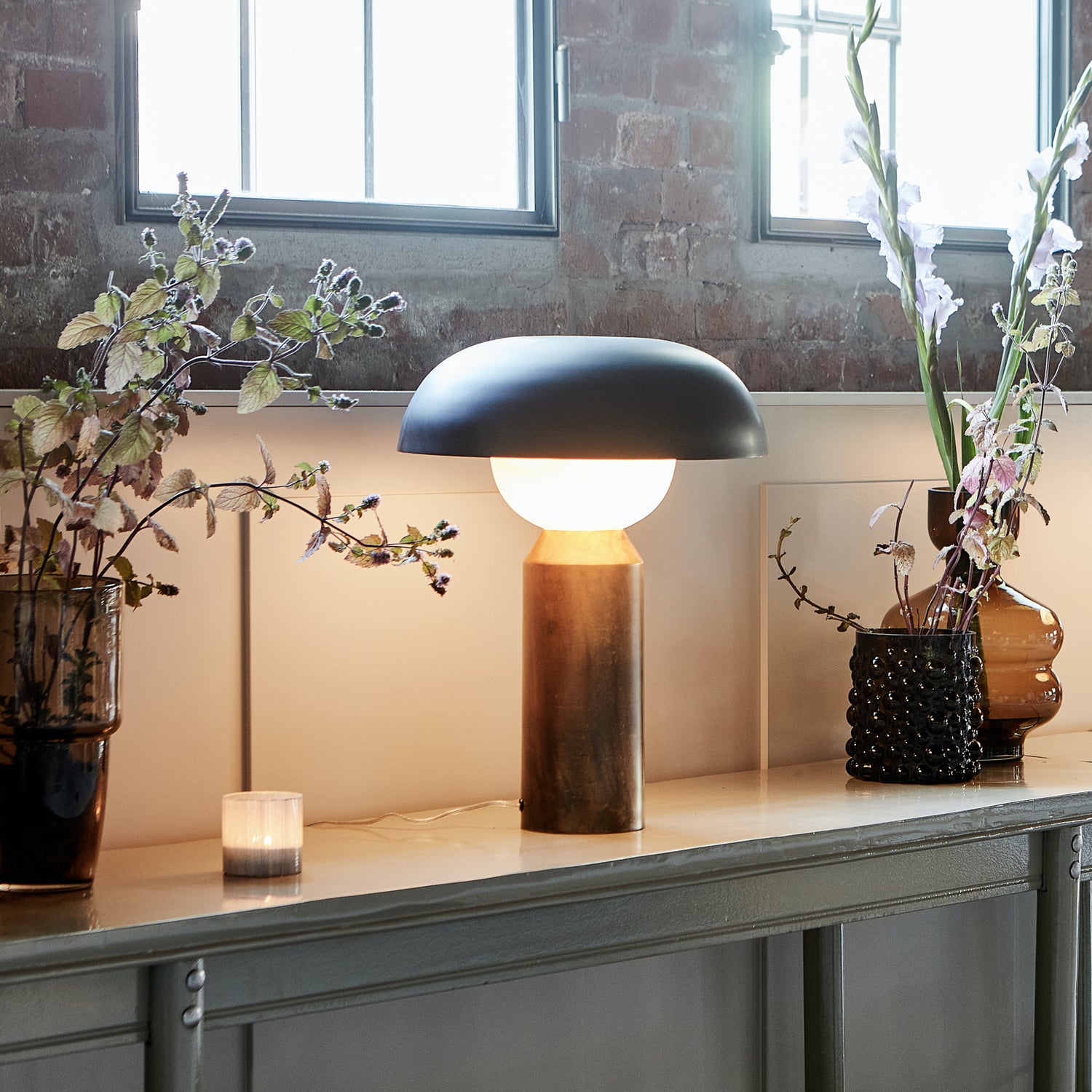Console table with a statement lamp and sculptural glass vases