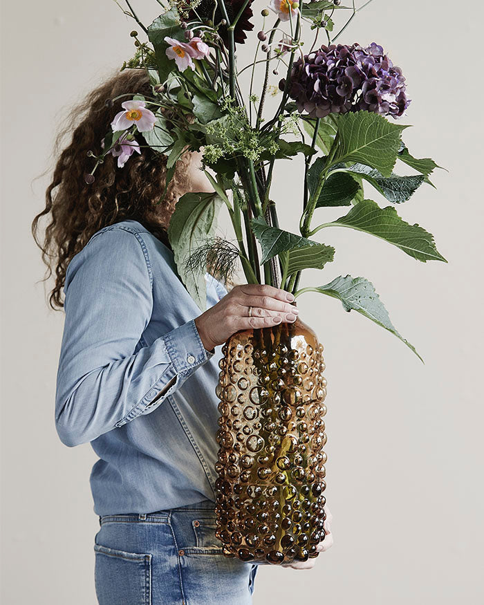 Tall bouquet in a brown glass vase